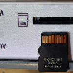 A photo of an SD card going into an SD card slot.